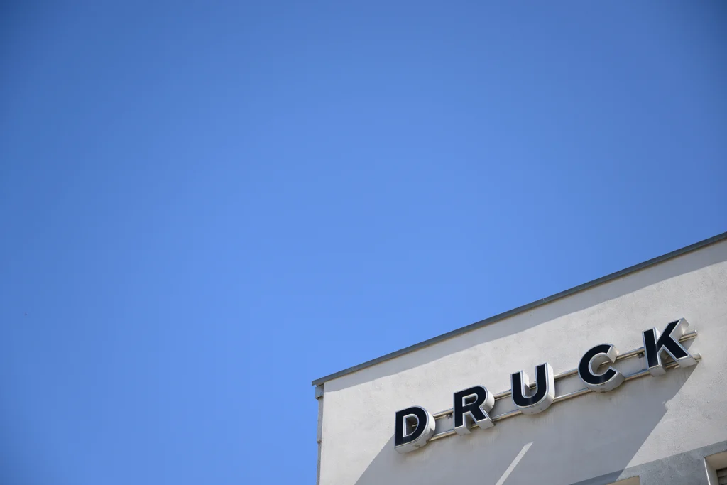 Eine Ecke des Hauses auf der die Buchstaben „Druck“ stehen